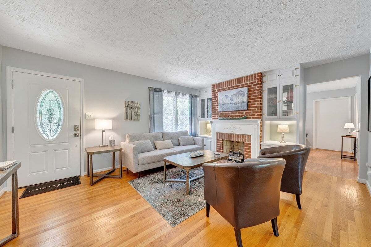 A living room with a fireplace, a sofa, a coffee table, and a door with a glass window.