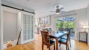 A spacious kitchen with white cabinets and a dining area with a wooden table and chairs. - Lakefront Tranquility - Lakefront Home With Views, Private hot Tub/dock, Deck, Free Wifi (Moneta)