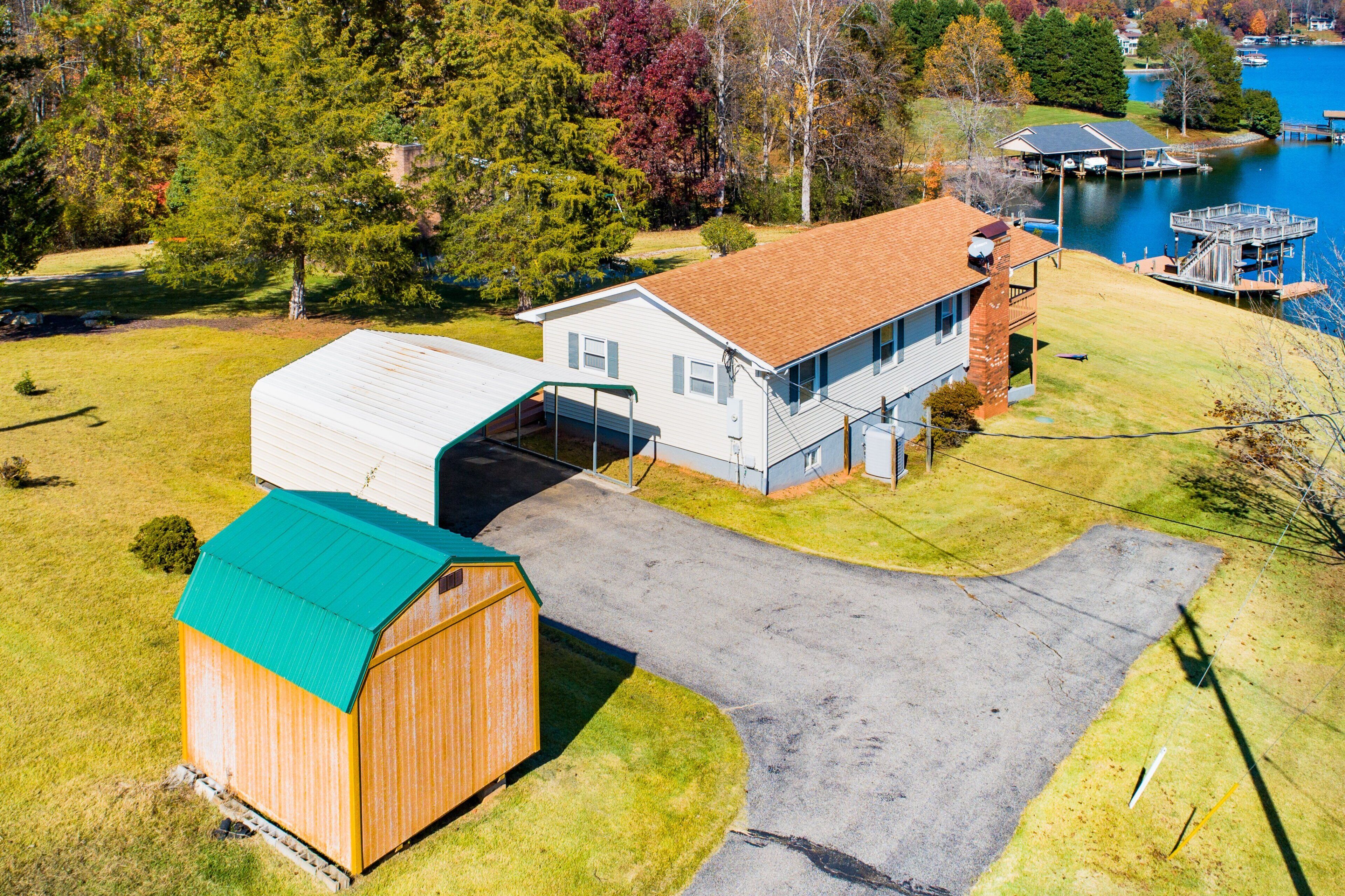 A residential property with a garage, a detached house, a dock, and a lake view.