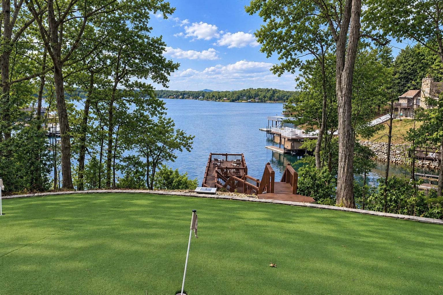A golf course with a water body in the background, a wooden dock, and a grassy area.