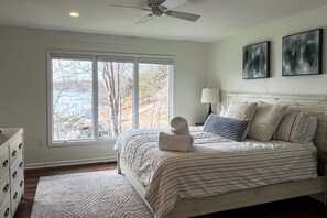 Une chambre à coucher avec un lit, une commode, une fenêtre et un ventilateur de plafond.
