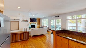 Una cocina moderna con suelo de madera, refrigerador empotrado y un ventanal con vistas al exterior.