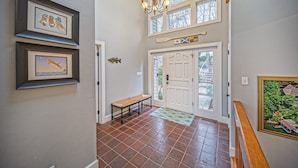 A hallway with a bench, a door, and framed pictures on the wall. - Our Point of View - Lakefront Home With hot Tub, Pool Table, Dock - Dog-friendly (Huddleston)