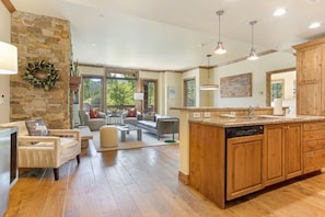 A spacious kitchen with wooden cabinets, a central island, and a dining area with a sofa and chairs.
