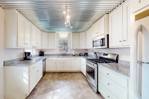A kitchen with white cabinets, a stainless steel range, a microwave, and a sink. - Evergreen - Lakefront Home With Dock, Screened Porch, AC & Kayaks (Moneta)