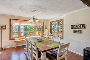 Un comedor con una mesa de madera, sillas y un banco.