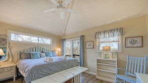 A bedroom with a bed, bench, bedside table, lamp, and a ceiling fan. - Cottage at the Lake - Waterfront Lake-view Home With Dock, Fireplace, Pool Table, Kayaks, & Firepit (Moneta)