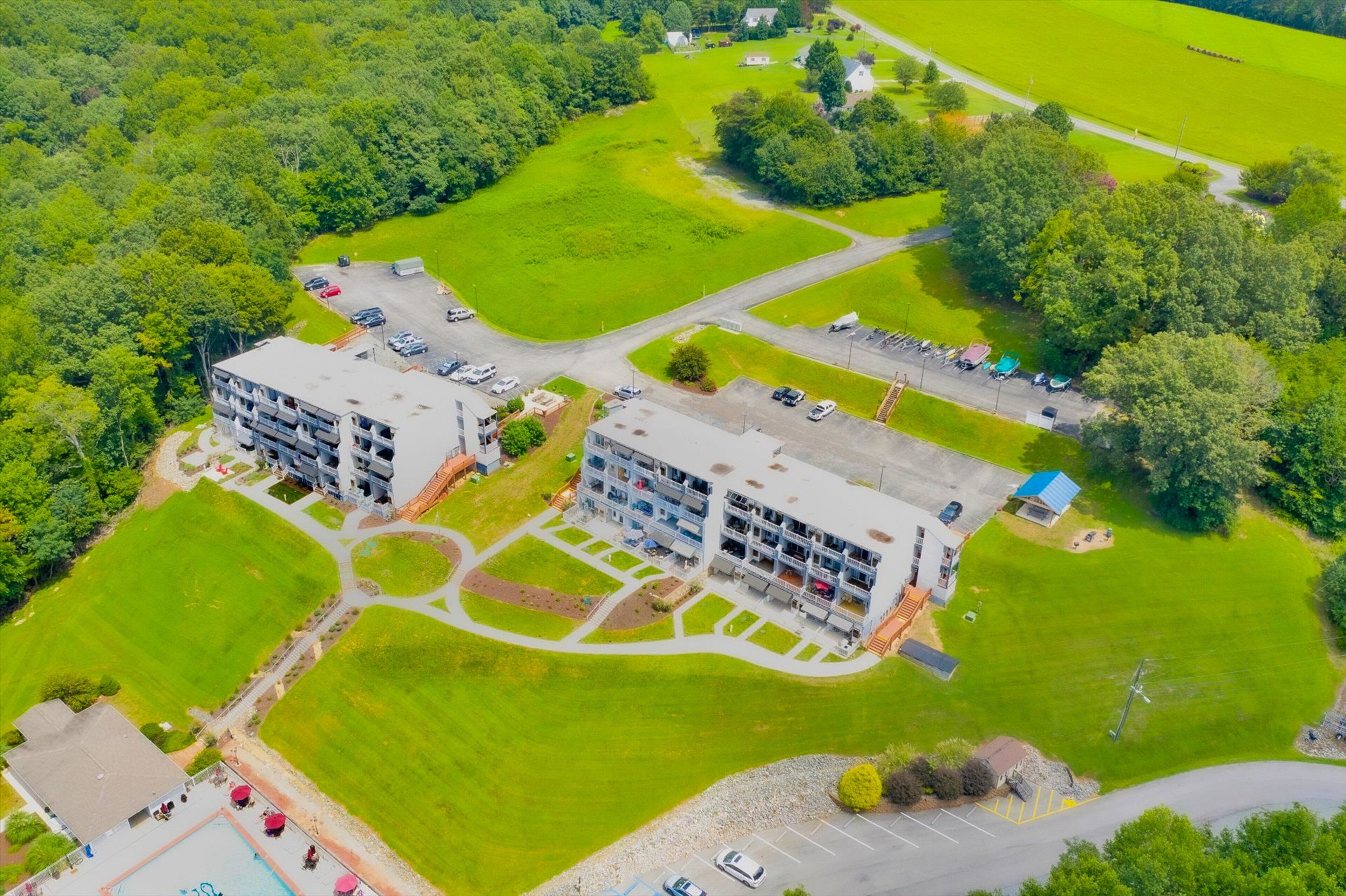 An aerial view of a hotel with multiple buildings, parking areas, and green spaces.