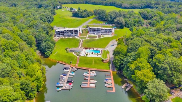 An aerial view of a resort with a marina, swimming pool, and lush greenery. - Sunset Landing - Waterfront Condo With Lake-view Deck, Tennis Court & Pool (Moneta)