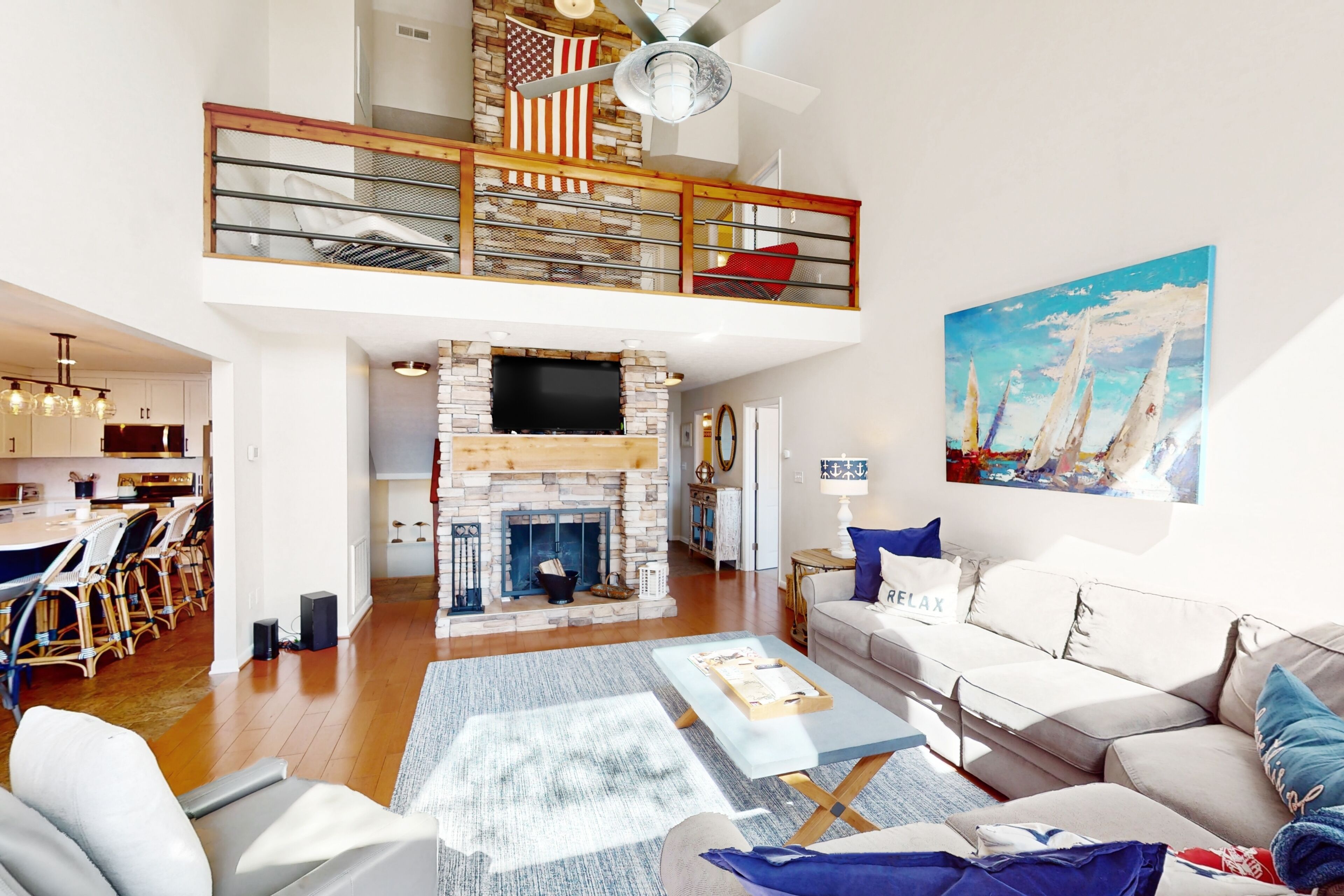 A spacious living area with a fireplace, a dining area, and a loft with a balcony.