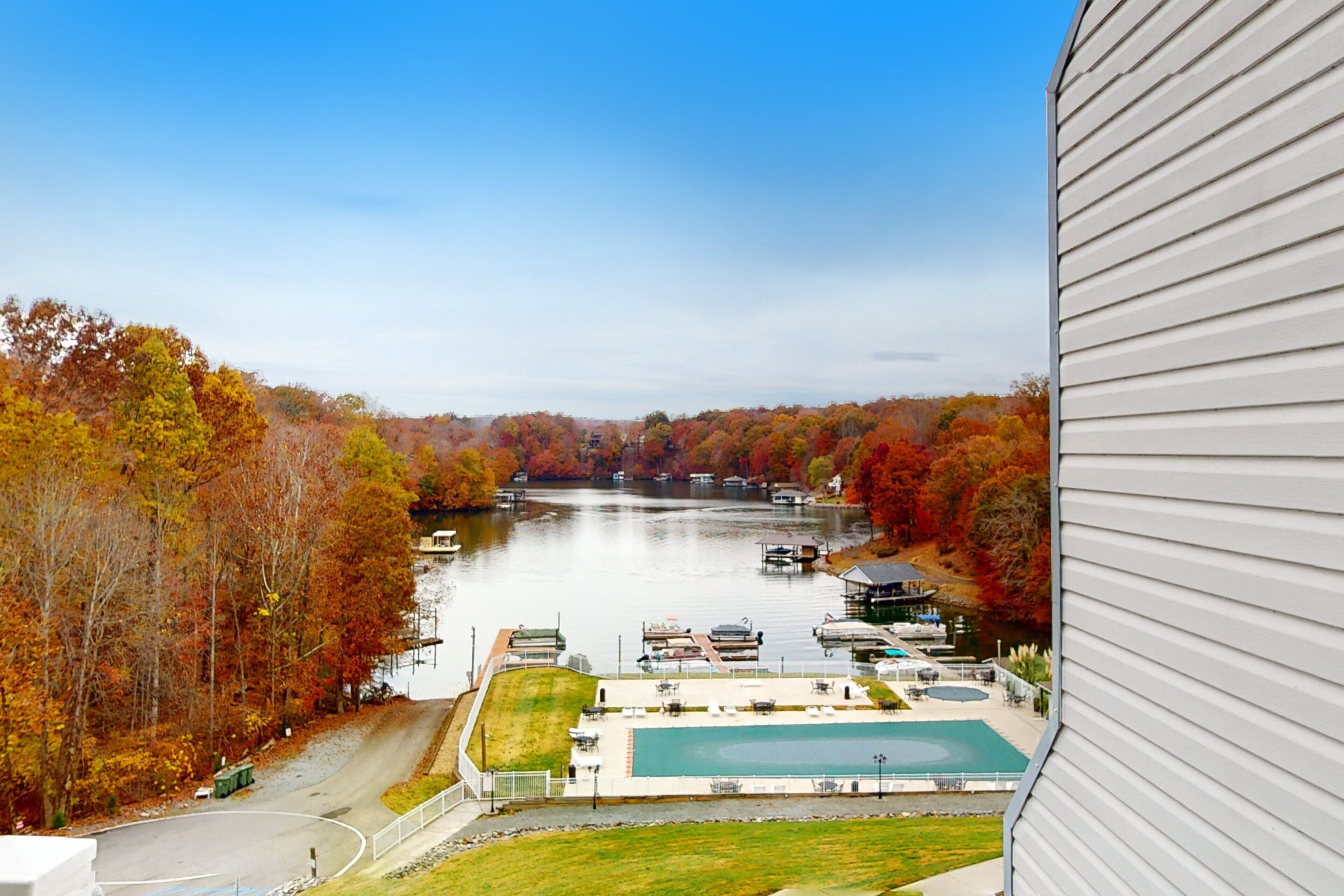 A view of a lake with boats, a swimming pool, and a dock area.