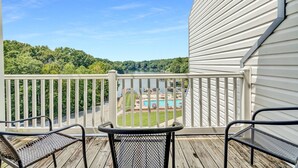 A balcony with a view of a pool and trees. - Reel Simple - Waterfront Striper's Landing Condo With Views, Pool & Boat Launch - Near Dining (Moneta)