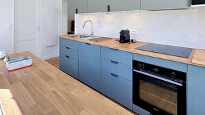 Ett modernt kök med en inbyggd ugn, en kaffebryggare och en diskho.