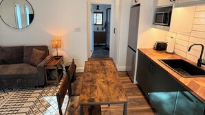 Een moderne keuken met een houten tafel, een inbouwmagnetron en een gootsteen.