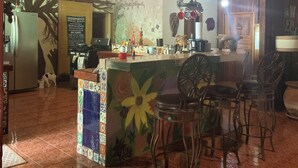 A restaurant interior with a bar area, chairs, a ceiling fan, and a mural on the wall. - 4-bedroom farmhouse in gorgeous Nuevo Colón with cool AC breeze (Nuevo Colón)
