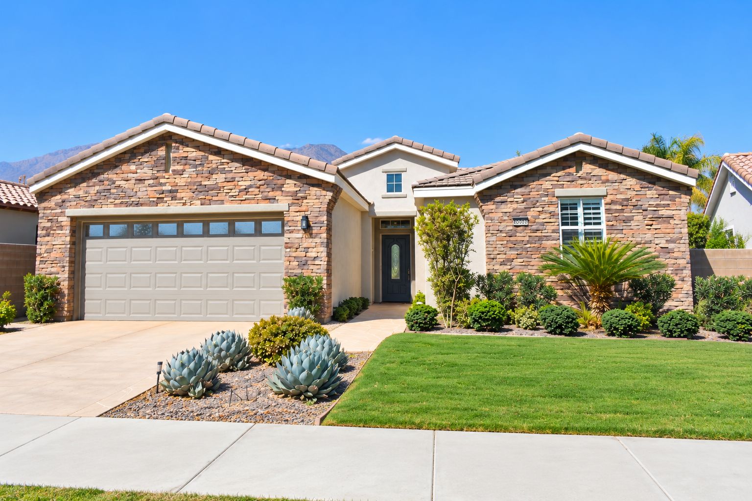 A two-story house with a garage, a front door, and a well-maintained lawn.