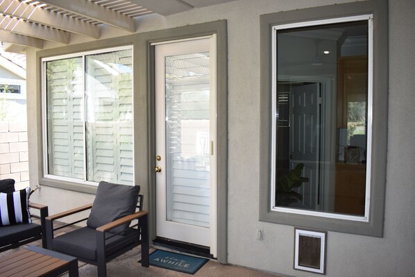 A front porch with a bench, a door, and a large window. - Juniper Jewel- desert home with private pool and spa, views, Pickle Ball 31 days (LA  Quinta)