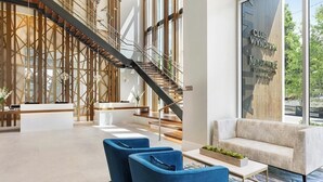 A modern lobby with a staircase, seating area, and a reception desk. - Downtown Atlanta Wyndham Studio Suite - World Cup Stay Near Stadium (Atlanta)