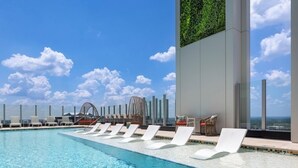 A rooftop pool with lounge chairs, a view of the city, and a green wall. - Downtown Atlanta Wyndham Studio Suite - World Cup Stay Near Stadium (Atlanta)