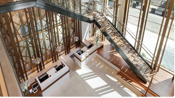 A modern interior with a glass staircase, wooden accents, and a view of the outdoors. - Downtown Atlanta Wyndham Studio Suite - World Cup Stay Near Stadium (Atlanta)