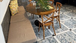 A dining area with a round wooden table, chairs, a bench, and a potted plant. - The house on the Iguazú River (Puerto Iguazú)