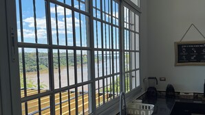 A kitchen with a large window, a sink, a kettle, and a chalkboard with writing. - The house on the Iguazú River (Puerto Iguazú)