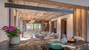 Una cocina moderna con encimera de madera, estufa y comedor con sillas y mesa.