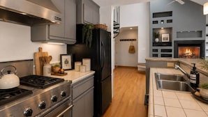 A modern kitchen with a gas stove, stainless steel appliances, and a built-in oven. - Sky Loft: Steps to skiing w/ hot tub! (Telluride)