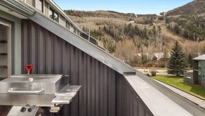 A modern building with a metal exterior and a view of a forested valley. - Sky Loft: Steps to skiing w/ hot tub! (Telluride)