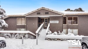 A two-story building with a sign reading 'STEMBOAT' and a staircase leading to the entrance. - Steamboat 2 - Central Village (Central Village)