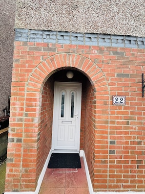 A brick entrance with a white door, a black mat, and a number plaque. - Elegant and Serene 4-bedroom retreat house in charming Drogheda (Drogheda)
