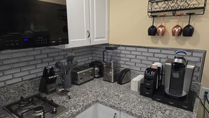 A kitchen with a gas stove, a microwave, a coffee maker, and a toaster. - Private Studio - 10 minutes from LV Strip, airport, and Convention Center (Las Vegas)