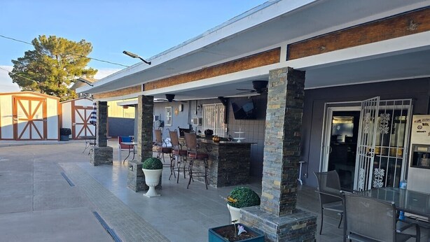 A modern building with a covered patio area, outdoor seating, and a bar. - Private Studio - 10 minutes from LV Strip, airport, and Convention Center (Las Vegas)
