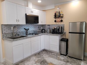 A kitchen with white cabinets, a stainless steel refrigerator, a microwave, and a coffee maker. - Private Studio - 10 minutes from LV Strip, airport, and Convention Center (Las Vegas)