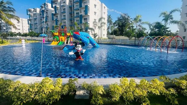 A swimming pool with a water fountain, a Mickey Mouse figure, and a colorful play structure. -  Cozy 3BR Condo with AC at Negombo Santorini Resort, Close to Airport (Negombo)