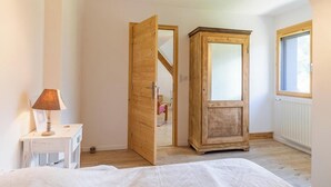 Makuuhuoneessa on sänky, puinen vaatekaappi, lamppu ja ikkuna.