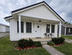 A single-story house with a front porch, a door with the number 802, and a small garden area with shrubs. - Cozy 2-Bedroom Home in the Heart of Manchester (Manchester)