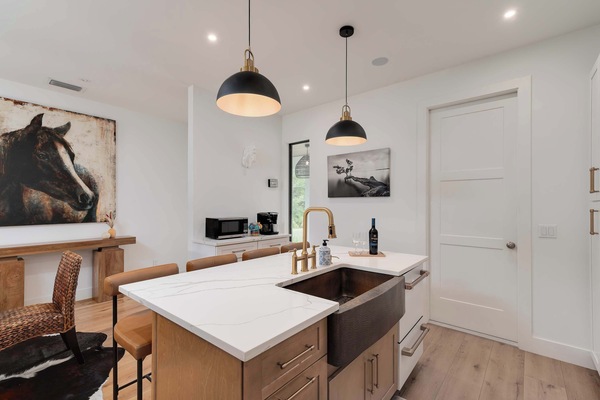 Modern kitchen island with marble countertop and brass fixtures