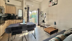 Una cucina moderna con angolo ristoro, divano e mobile TV.