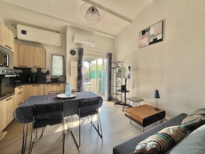 A modern kitchen with a dining area, a sofa, and a TV stand. - CAP D'AGDE - Plage Richelieu / Réf 418 (CA P D'AGDE)