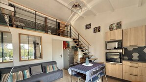 Un appartamento moderno con zona pranzo, cucina e una scala che conduce a un livello superiore.