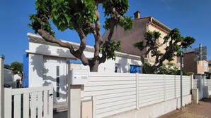 A gated residential area with a white building, a tree, and a clear blue sky. - Lovely studio fo 2 or 3 people, only 100m away from the beach of Portiragnes plage (PORTIRAGNES)