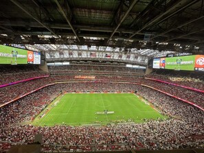 A large indoor stadium with multiple tiers of seating, a central field, and various advertisements on the walls.