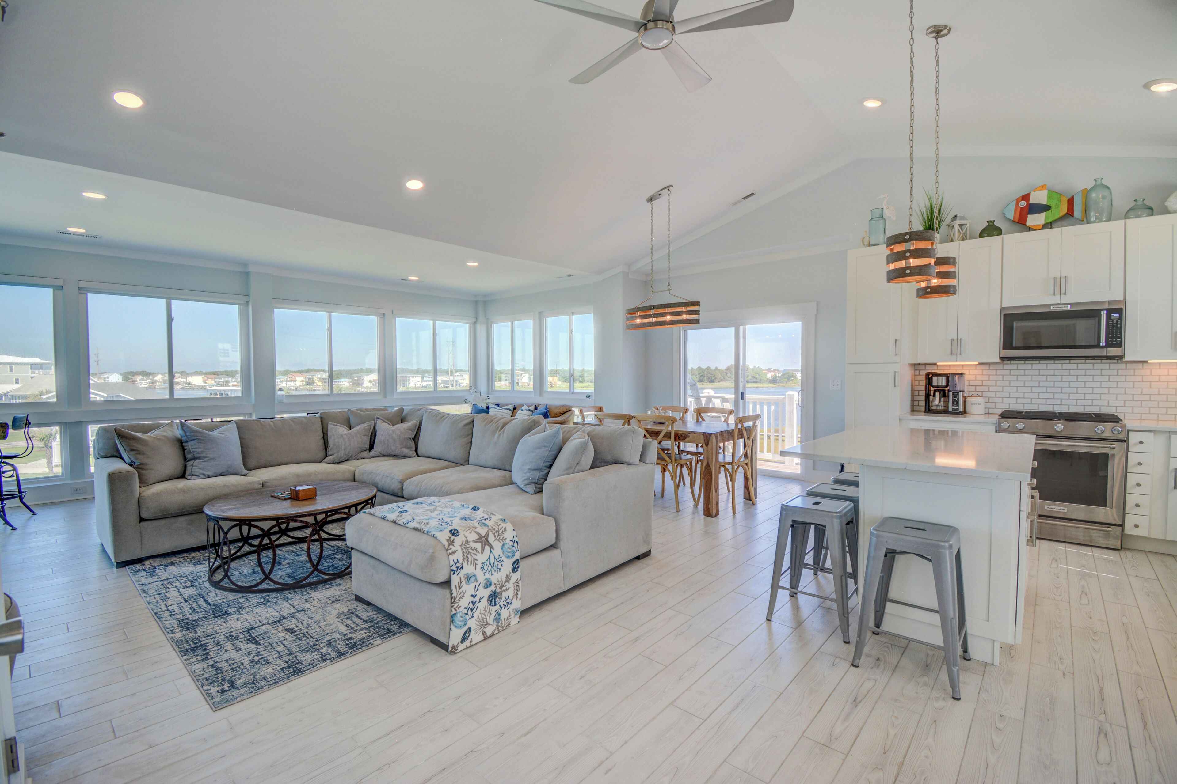 A spacious living area with a large sectional sofa, a dining table, and a kitchen with modern appliances.