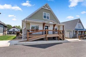 A residential house with a front porch, a wooden staircase, and a driveway. - Shore Thing | Steps to Pool | Hot Tub + Pool Table (Hollister)