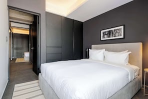 A modern hotel room with a large bed, a walk-in closet, and a framed picture on the wall. - w* | Well-Appointed 2BR w/ Balcony in Tabacalera (Ciudad de México)