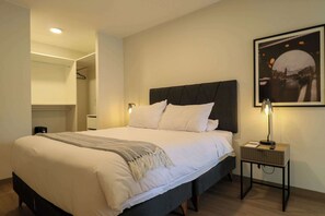 A neatly made bed with a headboard, a bedside lamp, and a framed picture on the wall. - w* | Trendy & Cozy 2BR w/ Balcony in Miraflores (Miraflores)