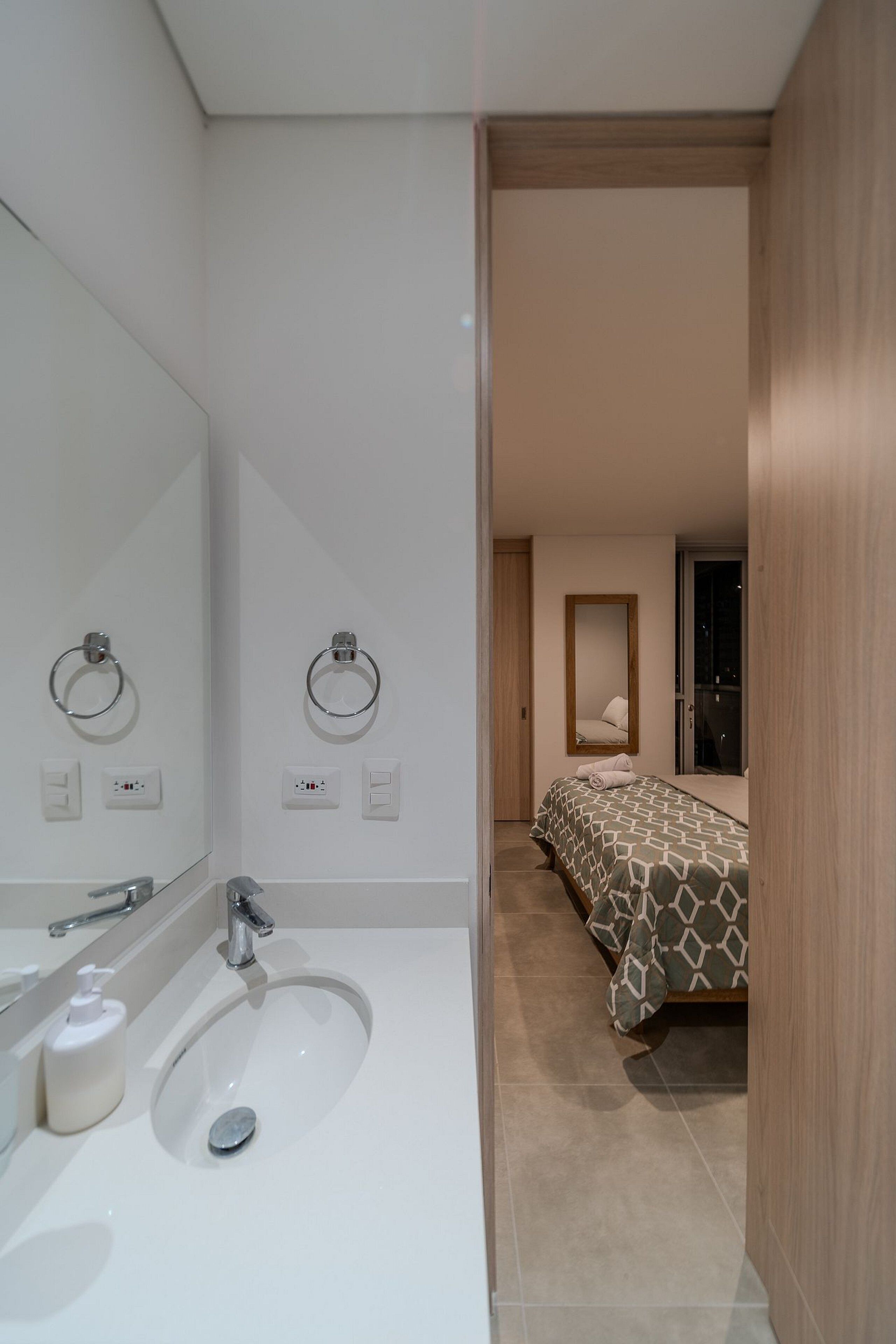 Une salle de bain moderne avec un lavabo, un miroir et des porte-serviettes.
