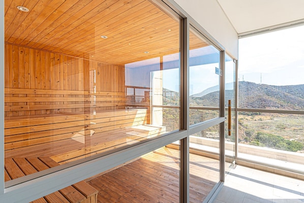 A modern interior with wooden paneling and large windows offering a view of a hilly landscape. - Salguero Suites by RV Stays (Santa Marta)