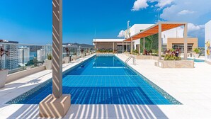 Una piscina en la azotea con vistas despejadas del horizonte de la ciudad.